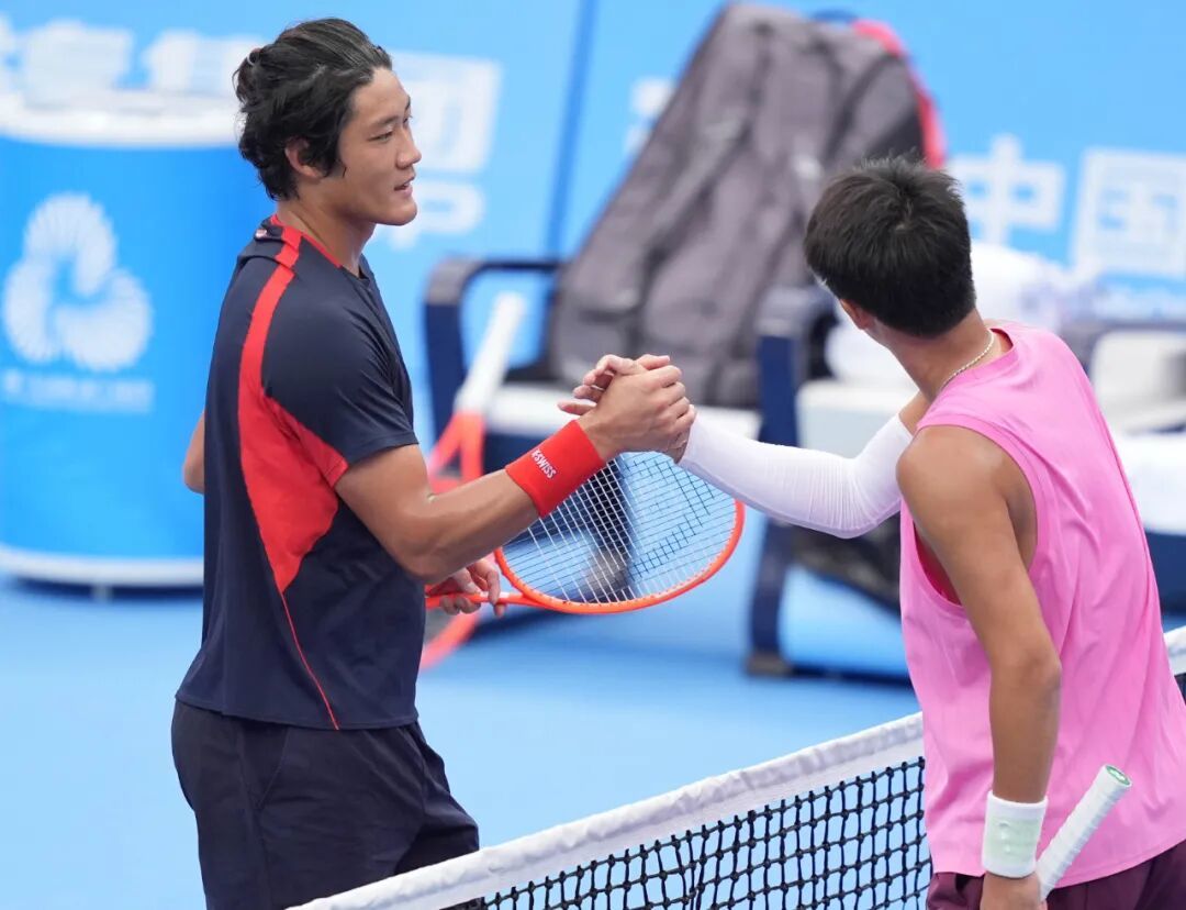 11月13日,第十五届全国运动会网球项目男子单打第一轮在珠海横琴举行。上海队选手张之臻(左)与湖南队选手周洺舟在赛后握手致意。
