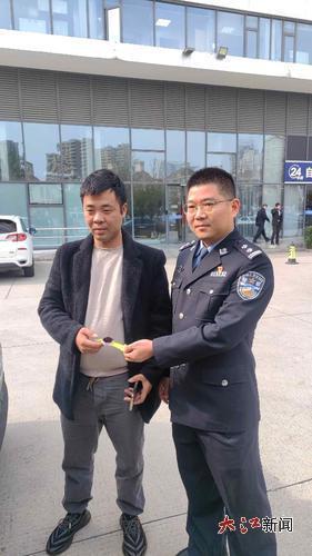 滴滴司机将找到的手表交给民警刘伟(右)。