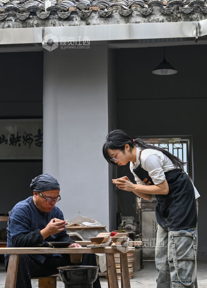 伍映山带领学生为陶瓷土坯清理灰尘。