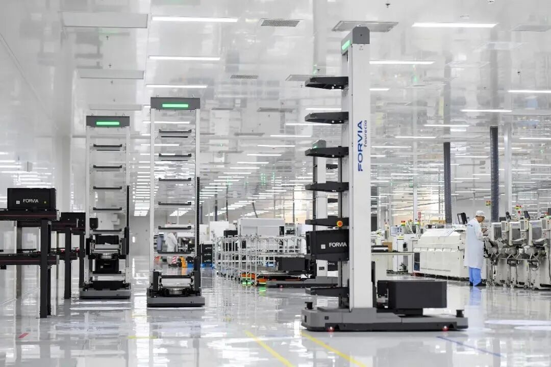 在佛吉亚歌乐电子(丰城)有限公司的超级工厂内，AGV机器人在工厂车间内穿梭。