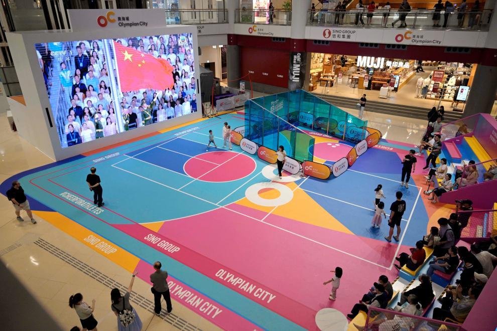 11月9日，第十五屆全國運動會開幕式在廣東奧林匹克體育中心舉行，這是香港市民在一家商場內觀看直播。新華社發（盧炳輝 攝）