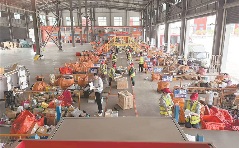 峡江县域配送体系快递集配中心内,快递公司员工正在进行分拣作业。(峡江县工信商务科技局供图)