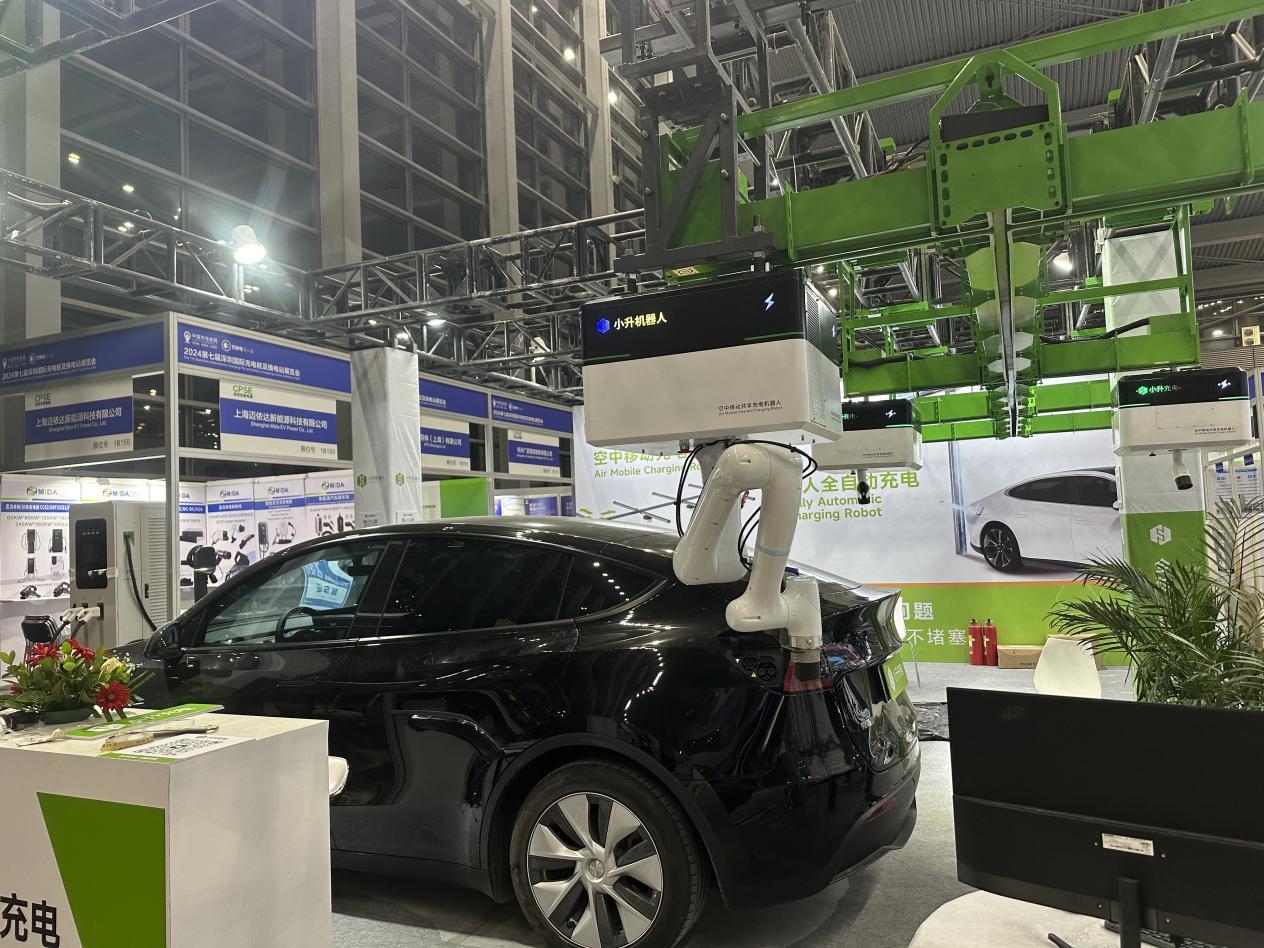 图为:小升机器人为新能源车充电。