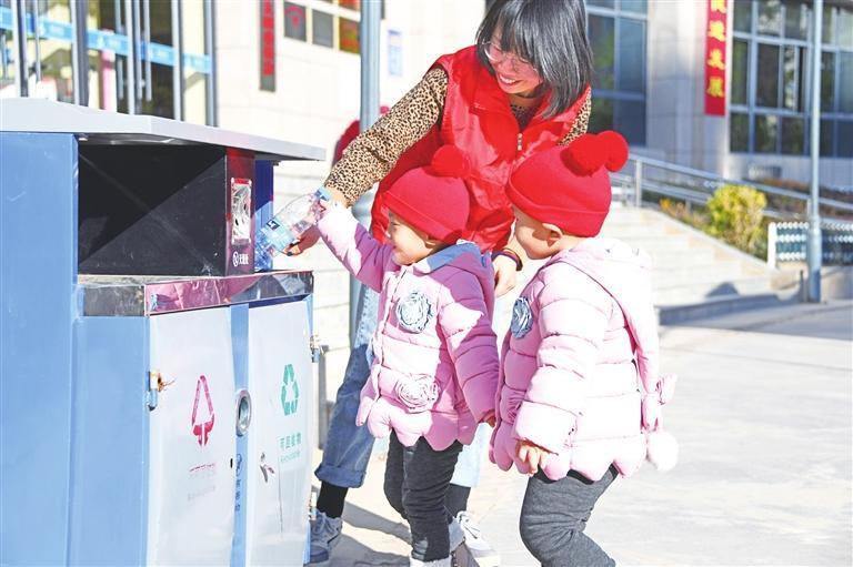 社区志愿者教孩子们学习垃圾分类的知识