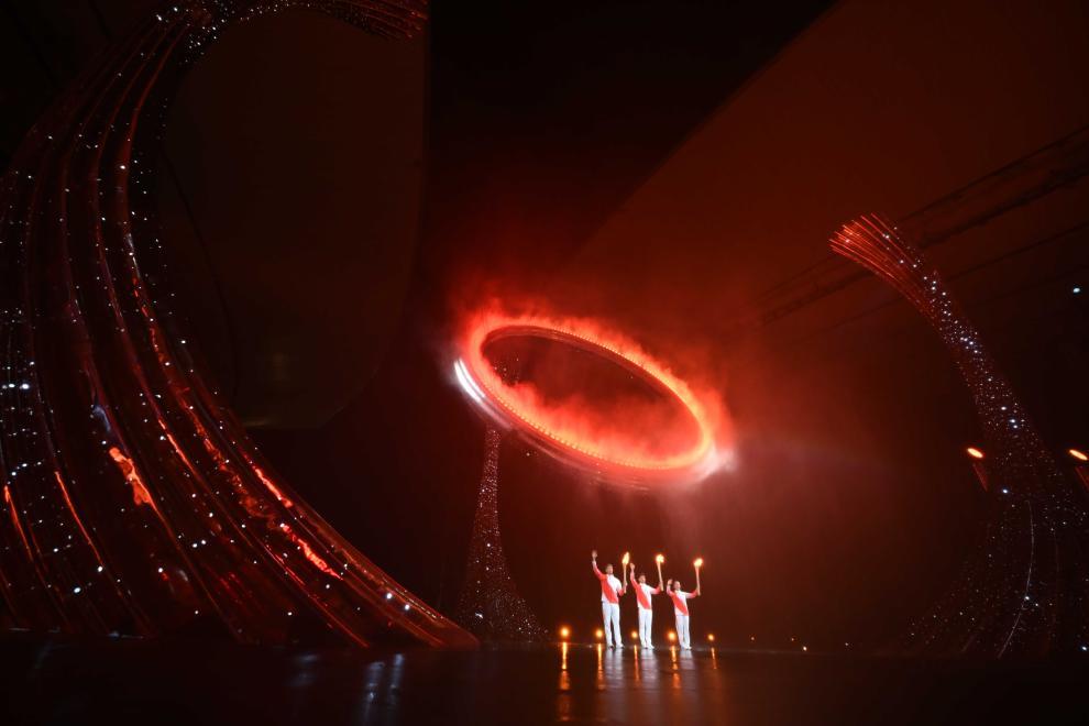 11月9日，火炬手蘇炳添（中）、張家朗（左）、李禕點燃主火炬後向觀眾致意。新華社記者 肖藝九 攝