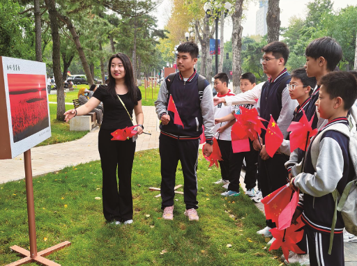 在长春市新民大街,教师在影展现场给学生上生态课。 潘晟昱 摄