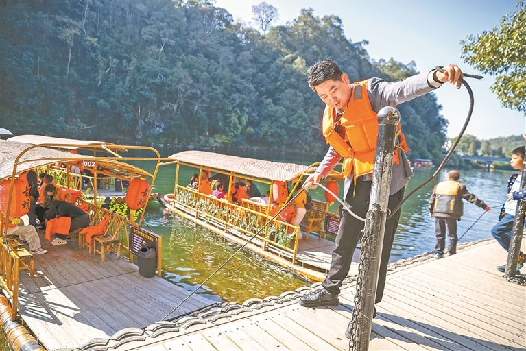 11月15日,婺源县江湾镇汪口村古渡口,詹淦周解开竹筏绳索,准备带着游客乘筏赏景。