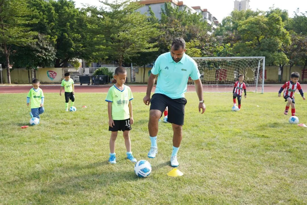 图：教练在五人制球场带领学员学习足球基础技巧