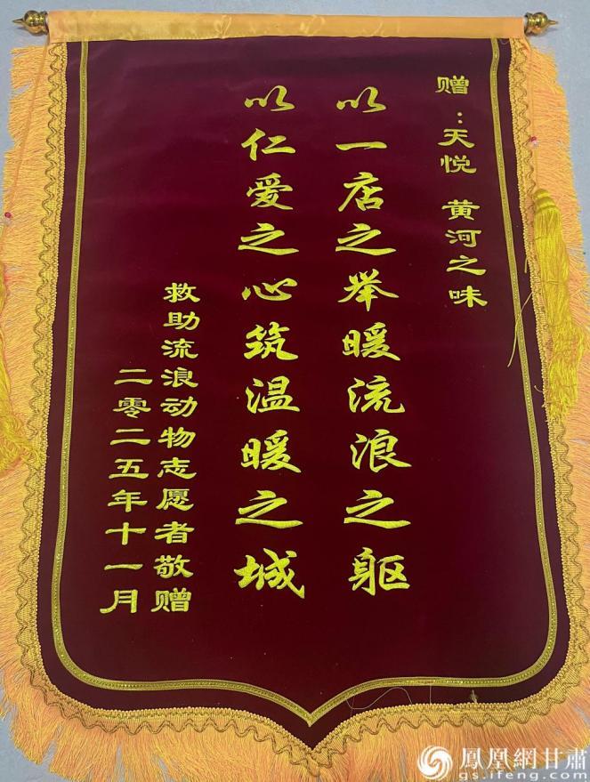 花福玲向免费为流浪动物提供食物的爱心酒店送上锦旗