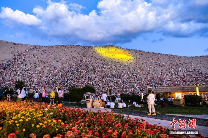 2024年7月28日，敦煌鸣沙山上，游客静待万人星空演唱会开幕。（资料图）王斌银　摄