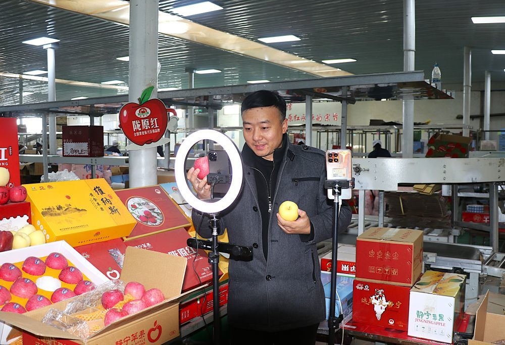 11月11日,在甘肃省平凉市静宁县工业园区的一家苹果企业,网络主播在推介静宁苹果。新华社发(王毅 摄)