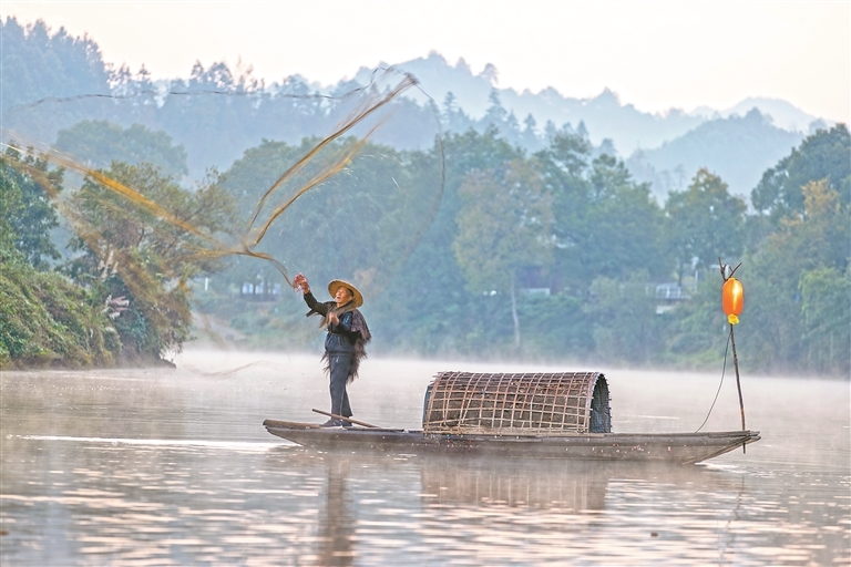 11月16日,婺源县秋口镇王村村月亮湾,61岁的俞树清穿着蓑衣、戴着斗笠,站在小船上“撒网捕鱼”。岸边,游客们架起相机,“咔嚓”的快门声此起彼伏。成为专职的“撒网模特”后,俞树清年均增收4万多元。