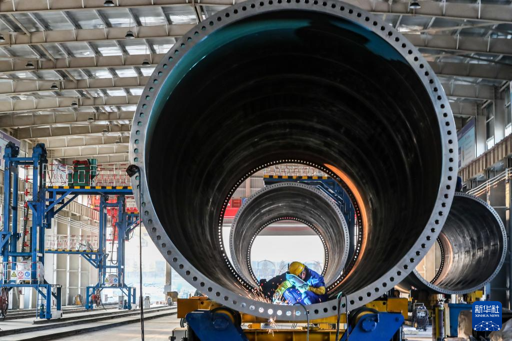 11月20日，在甘肃省酒泉经济技术开发区的中国水电四局（酒泉）新能源装备有限公司塔筒制造车间，工作人员进行风机塔筒焊接作业。