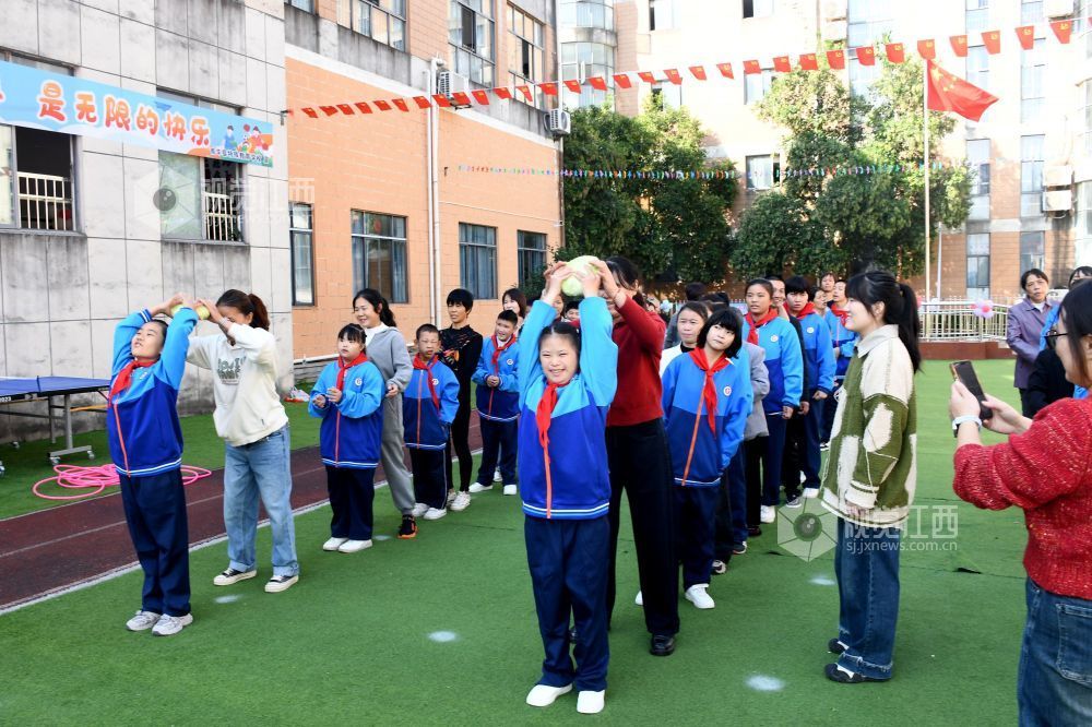 图为学生和家长在参加运送炸弹项目的比赛。