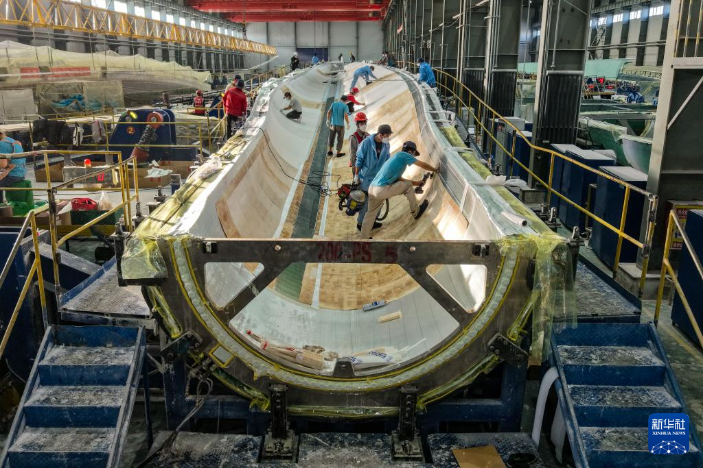 11月20日，在甘肃省酒泉经济技术开发区的甘肃九鼎风电复合材料有限公司成型车间，工作人员进行风机叶片铺层作业（无人机照片）。