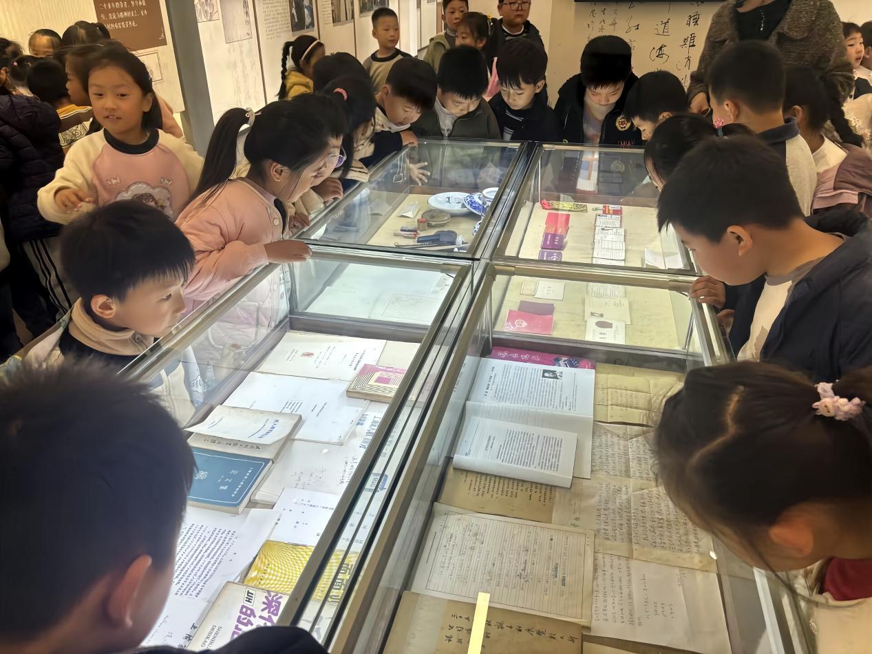 (图为孩子们围看楷模事迹。郭琳琳摄)