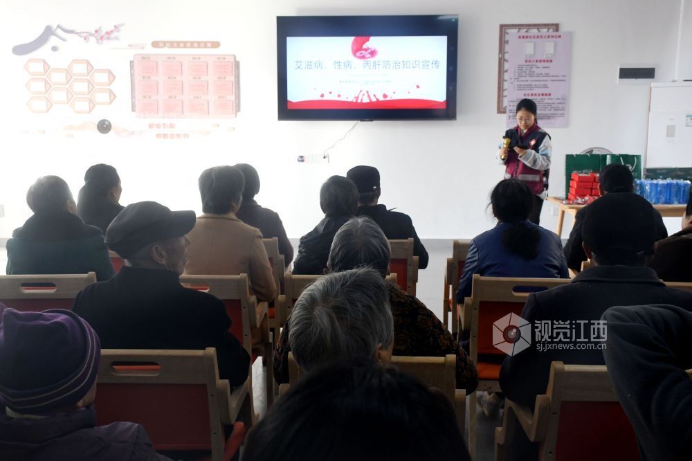 图为县疾控中心的工作人员为社区居民宣传防艾知识。