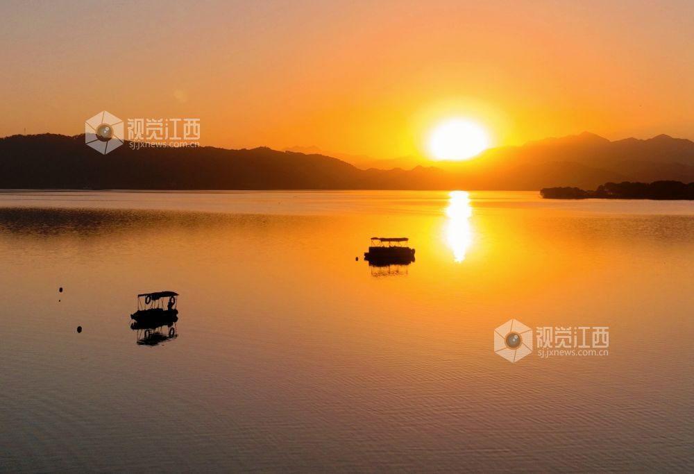 2025年11月26日，江西省分宜县钤阳湖在夕阳余晖的映照下，荡起层层涟漪，与远山丛林、湖中小船交相辉映，如诗如画，美不胜收。