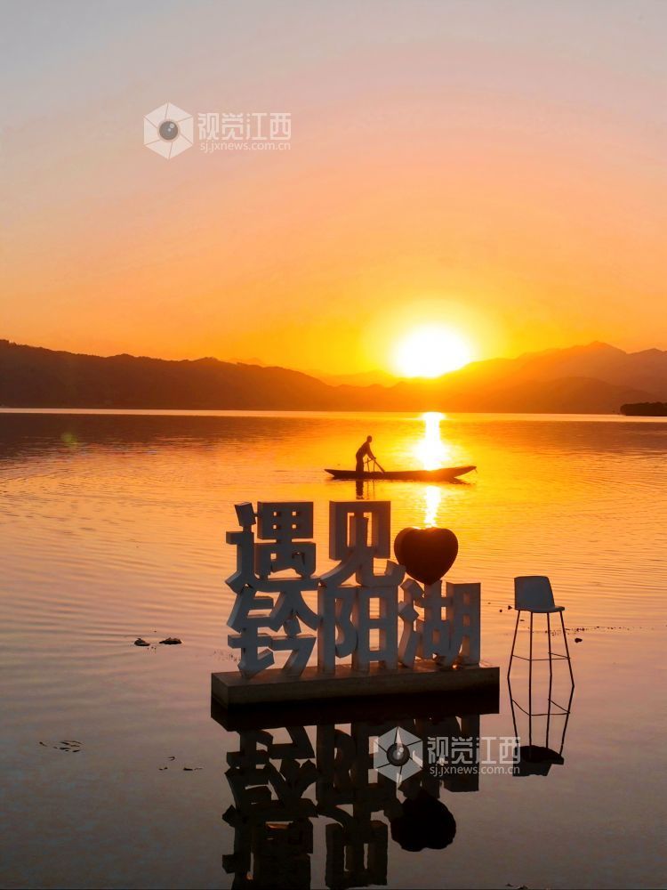 2025年11月26日，江西省分宜县钤阳湖在夕阳余晖的映照下，荡起层层涟漪，与远山丛林、湖中小船交相辉映，如诗如画，美不胜收。