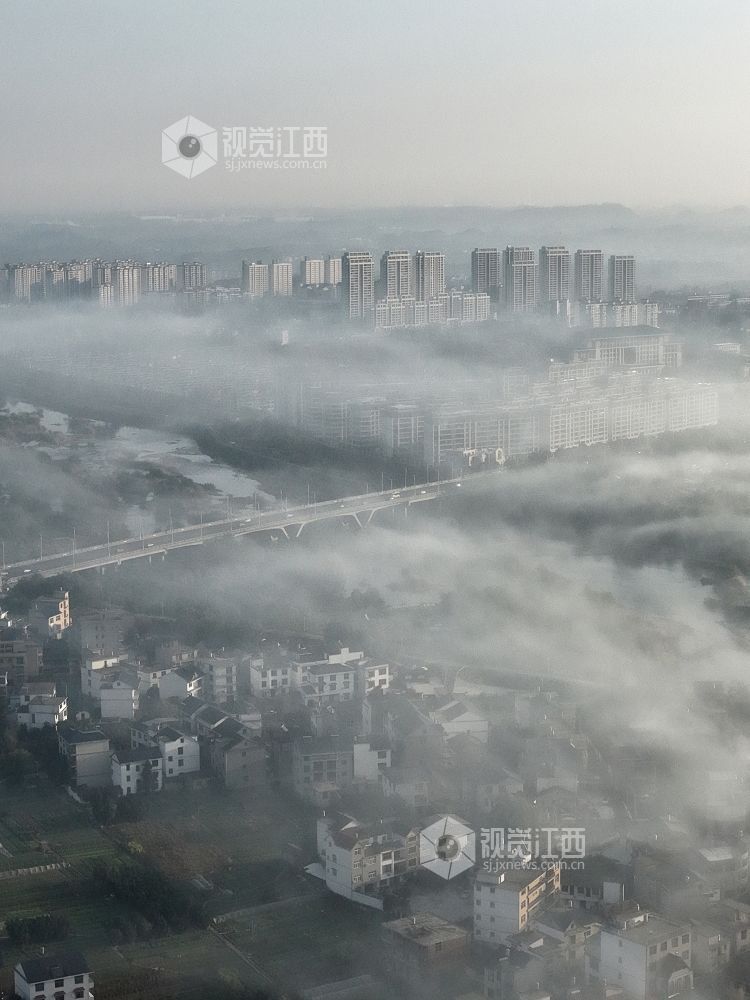 2025年11月24日,航拍江西省上饶市铅山县城乡晨雾如纱,轻柔地缠绕着城市楼宇与乡村民居,城市建筑与错落的村落相映成趣。