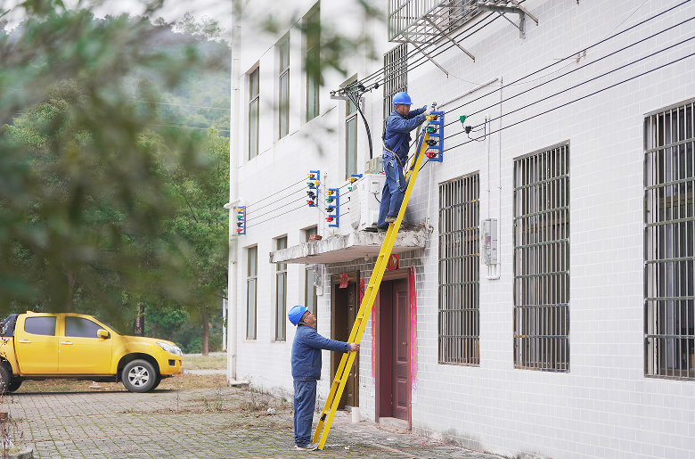 2024年12月10日,国网樟树市供电公司员工在店下镇黄家巷村委开展农村配网标准化示范台区建设。(龚可欣 摄)
