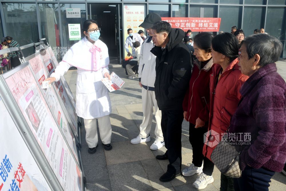 图为南丁格尔志愿服务队中医院分队志愿者利用防艾宣传展板为社区居民宣传防艾知识。