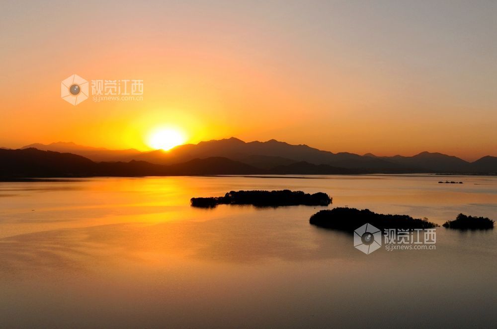 2025年11月26日，江西省分宜县钤阳湖在夕阳余晖的映照下，荡起层层涟漪，与远山丛林、湖中小船交相辉映，如诗如画，美不胜收。