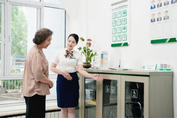 图:柜面服务人员为老年客户介绍适老化服务设施