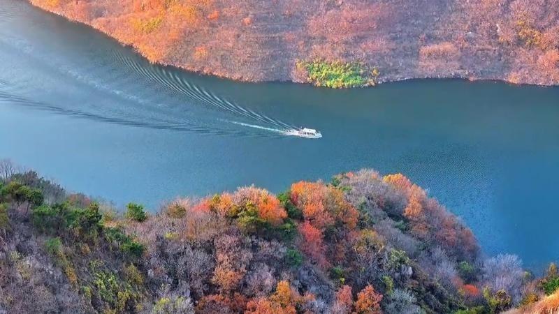 湖面如蓝绸舒展，两岸山林褪去翠绿，换上橙红、明黄的斑斓盛装。张宁 摄