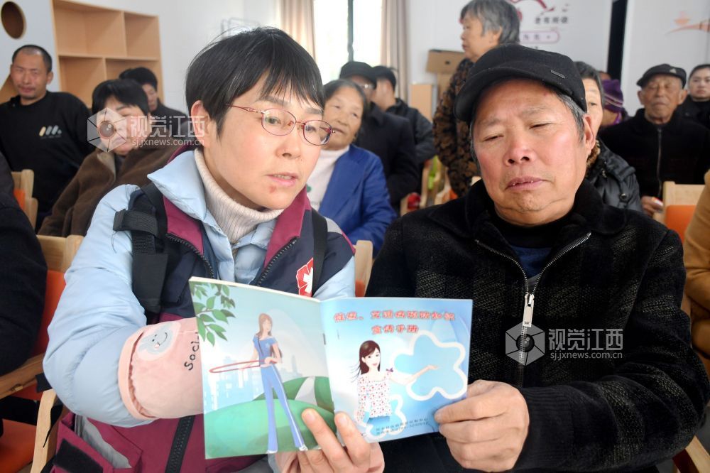 图为县疾控中心的工作人员利用防艾宣传资料为社区居民宣传防艾知识。