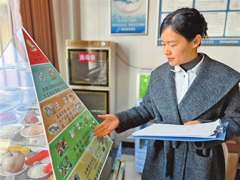 孙倩雯在介绍中国居民平衡膳食宝塔。记者 赵大明 摄