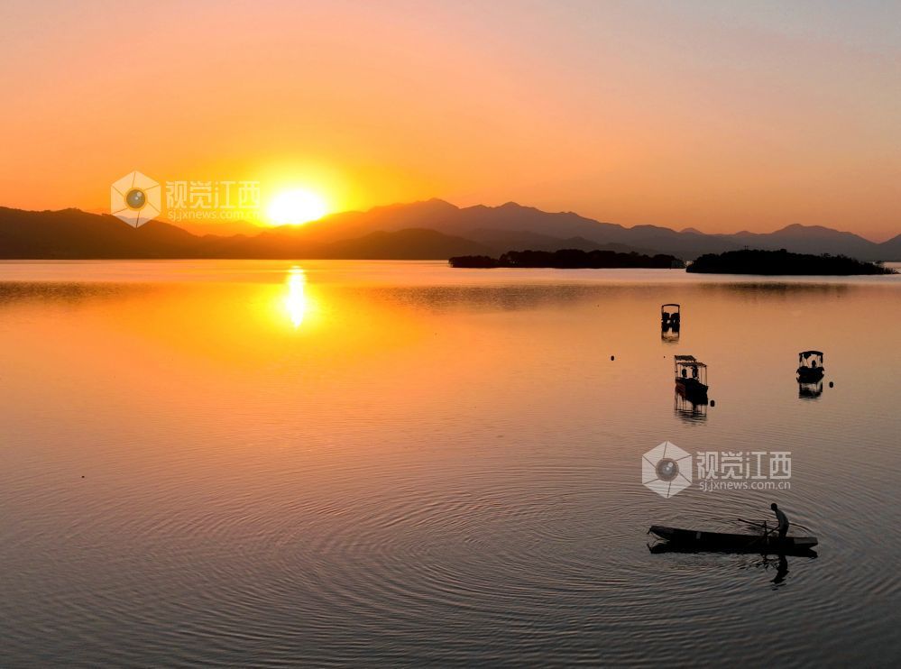 2025年11月26日，江西省分宜县钤阳湖在夕阳余晖的映照下，荡起层层涟漪，与远山丛林、湖中小船交相辉映，如诗如画，美不胜收。