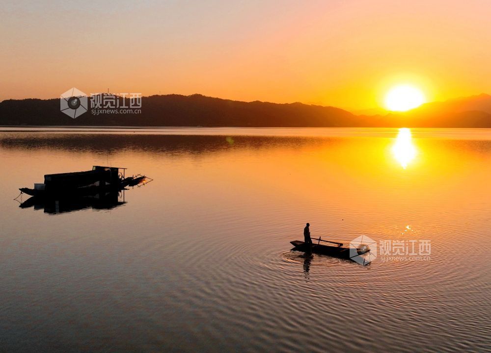 2025年11月26日，江西省分宜县钤阳湖在夕阳余晖的映照下，荡起层层涟漪，与远山丛林、湖中小船交相辉映，如诗如画，美不胜收。