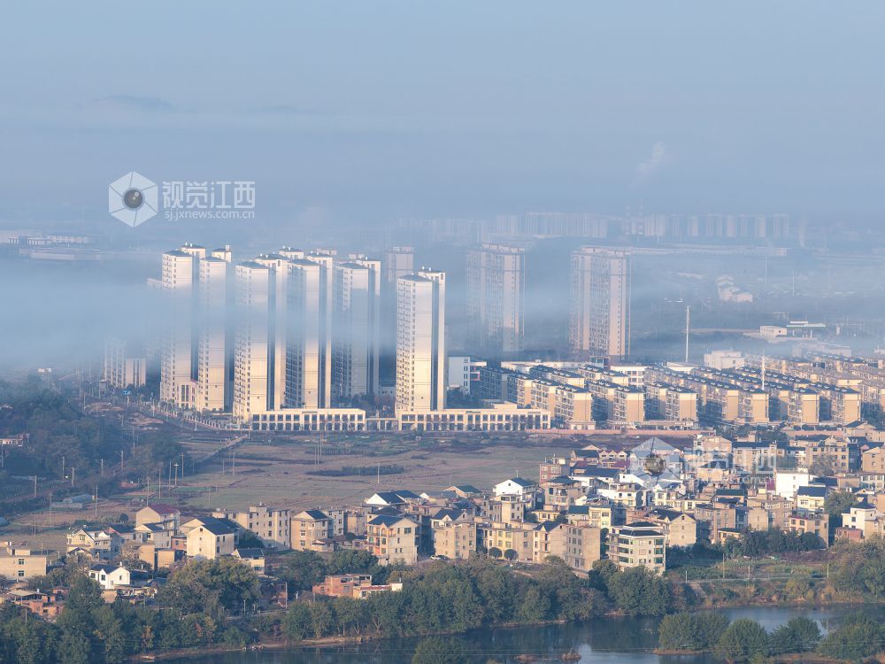2025年11月24日,航拍江西省上饶市铅山县城乡晨雾如纱,轻柔地缠绕着城市楼宇与乡村民居,城市建筑与错落的村落相映成趣。