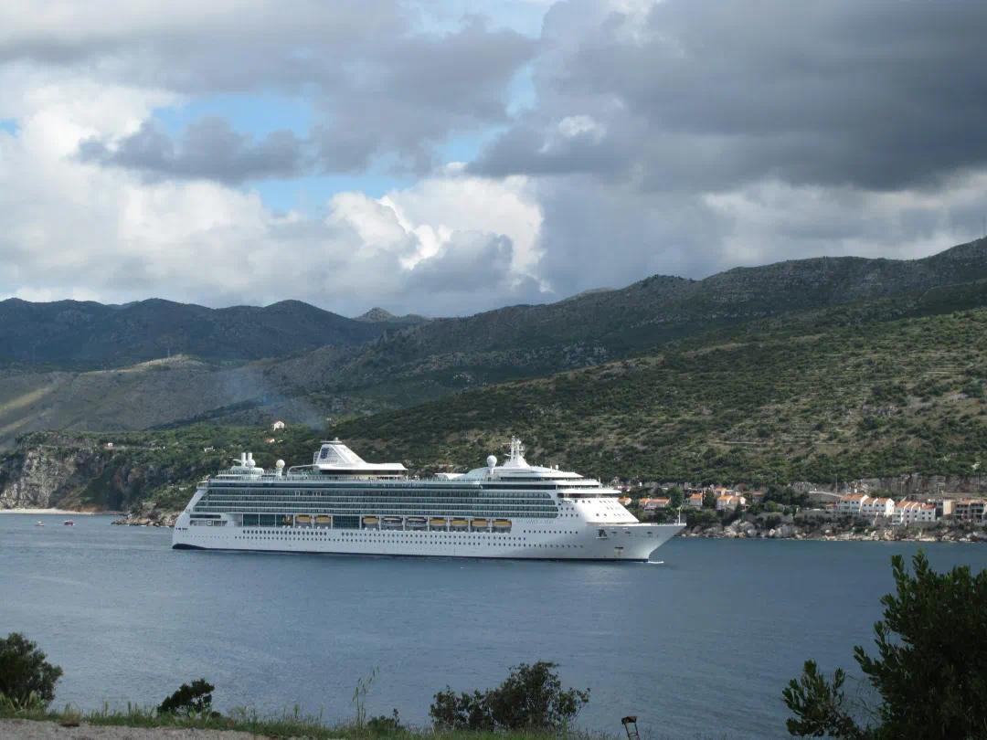 A cruise ship floats on calm water.