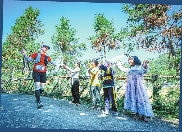 赛道沿途村庄的小朋友为选手加油。