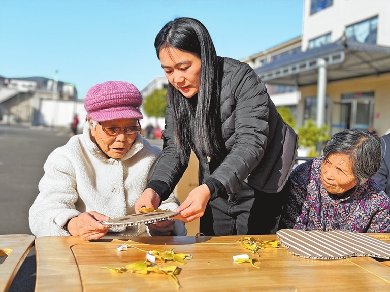 康珊珊在指导老人制作手工艺品。 记者 赵大明 摄