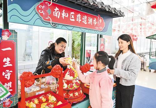 日前,在邢台市南和农业嘉年华景区非遗潮市,小游客被非遗手工花馍吸引。本报记者 赵永辉摄