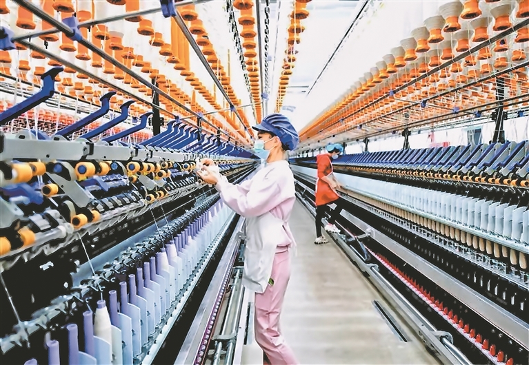 在江西卫棉纺织集团有限公司生产车间里,工人忙着加工棉纺产品。依托邮储银行于都县支行3500万元“科创信用贷”支持,企业打造“5G+智慧车间与循环再生”生产线。(于都县金融服务中心供图)