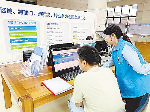 景德镇市一商户在工作人员指导下在网上提交审核资料。