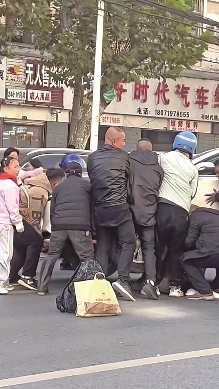 众人抬起肇事车辆 视频截图
