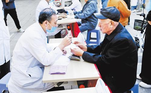 10月14日，在固安县“文明实践惠万家——‘医’路同行”爱心义诊活动现场，医生在为居民看诊。任 涵摄