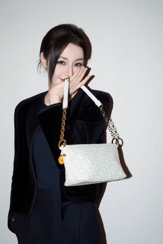 迪丽热巴捂嘴甜笑，娇俏少女感十足。