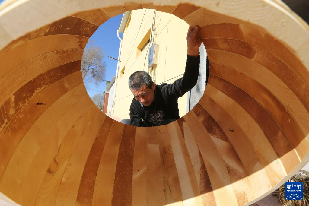 11月28日，手工艺人给牛皮鼓套环。新华社发（王克贤　摄）