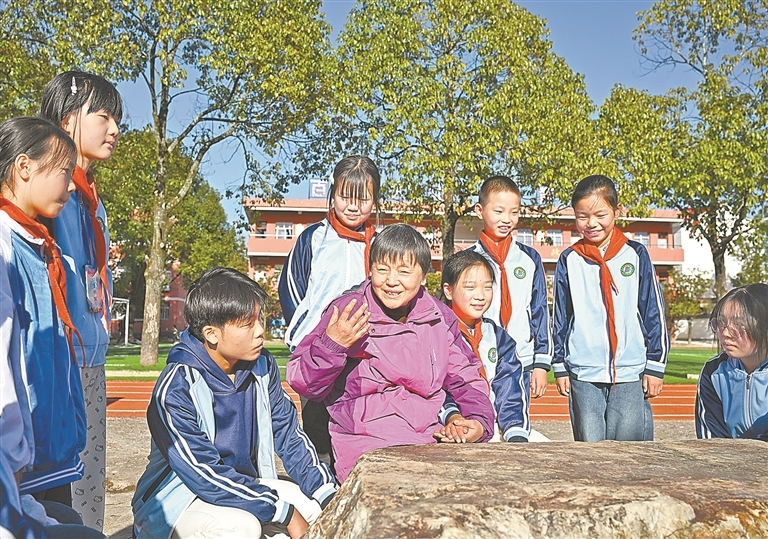 11月26日，在莲花县坊楼镇南陂中小学，甘公荣与“红娃娃”儿童志愿者服务队的孩子们交流谈心，讲述红色家风故事。