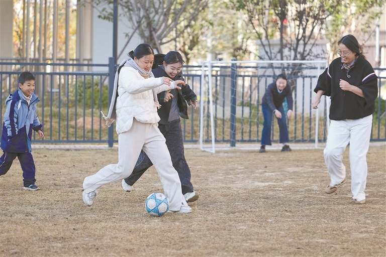 市民在赣州蓉江新区玉兰路口袋体育公园踢球。