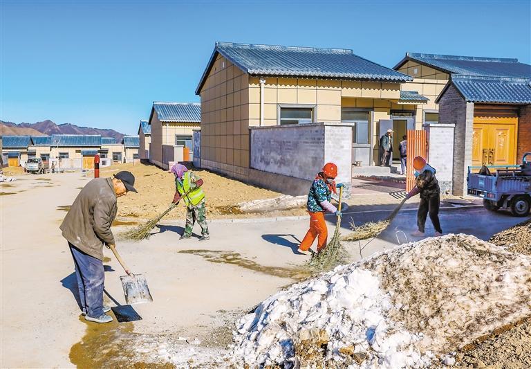 榆中县马坡乡旧庄沟村安置点，就近务工村民在清理道路。