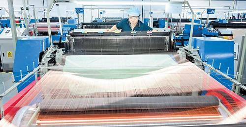 11月20日，在安平县赛航丝网制造有限公司生产车间，工人查看织网机运行情况。