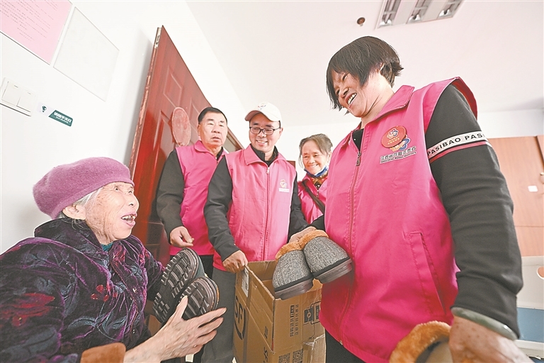11月7日，莲花县巾帼志愿服务协会会长陈满娇（右一）来到当地敬老院，为老人送上自己缝制的棉鞋。