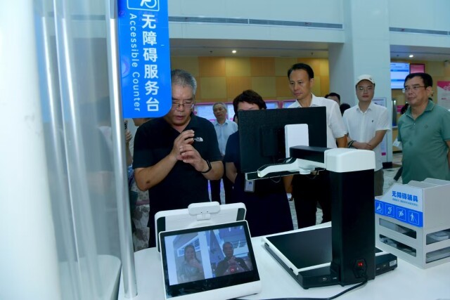 听力残疾人士徐志（左一）在省妇幼门诊大厅用固定无障碍服务终端与手语老师交流。洪志 摄